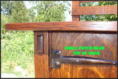 Detail of upper exposed through tenon, hand hammered iron strap hinge and a small wood repair patch near the top edge of the door.